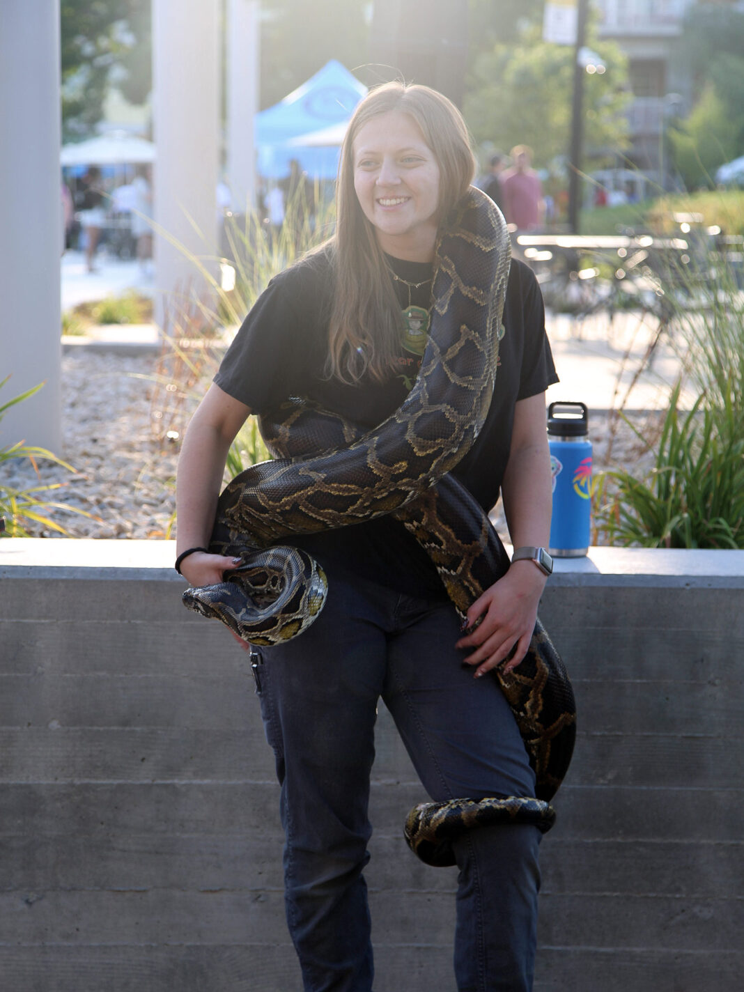 Large snake wrapping around Emily, the handler