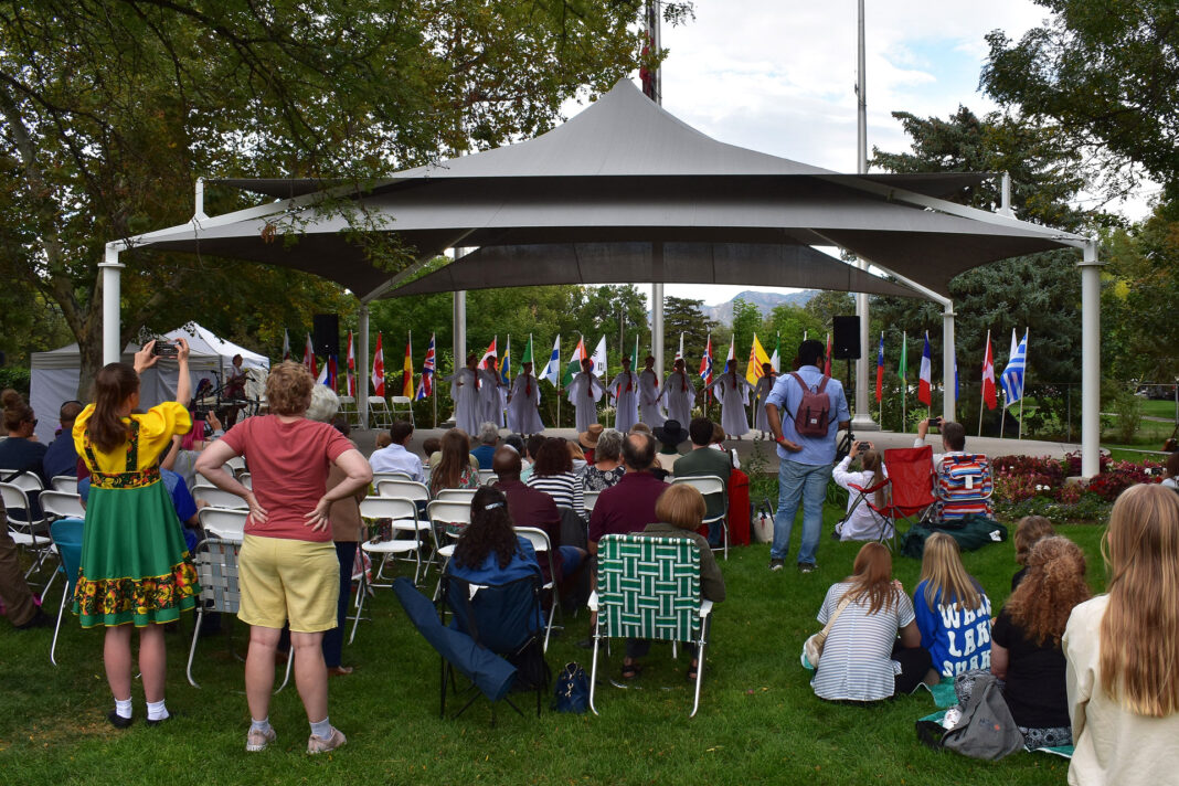 Crowd, in foreground, watching dancers under a gazebo