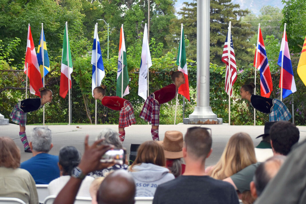 Two pairs of dancers facing each other as spectators watch