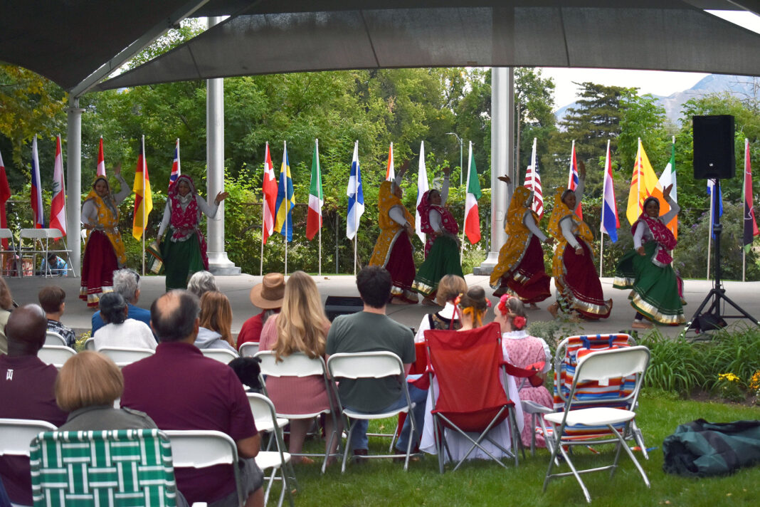 Spectators watching a group of dancers performing under a gazebo