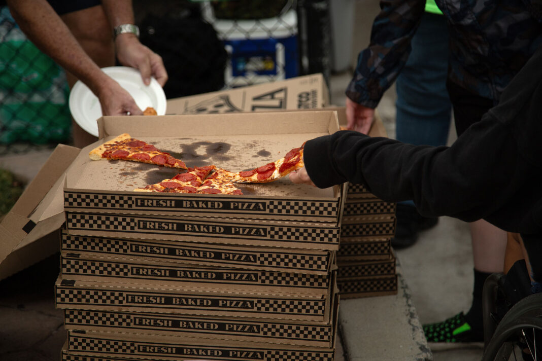 Event attendees grabbing slices of pizza