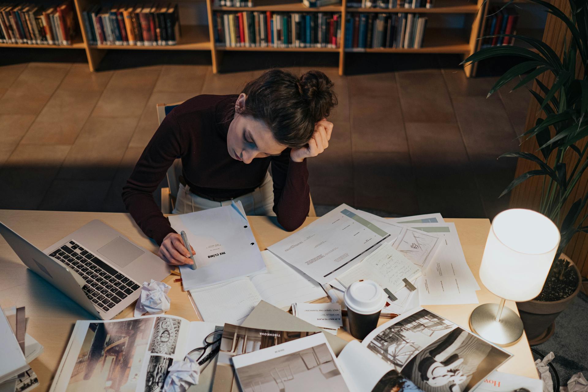 Woman reading a script while sitting at a cluttered desk