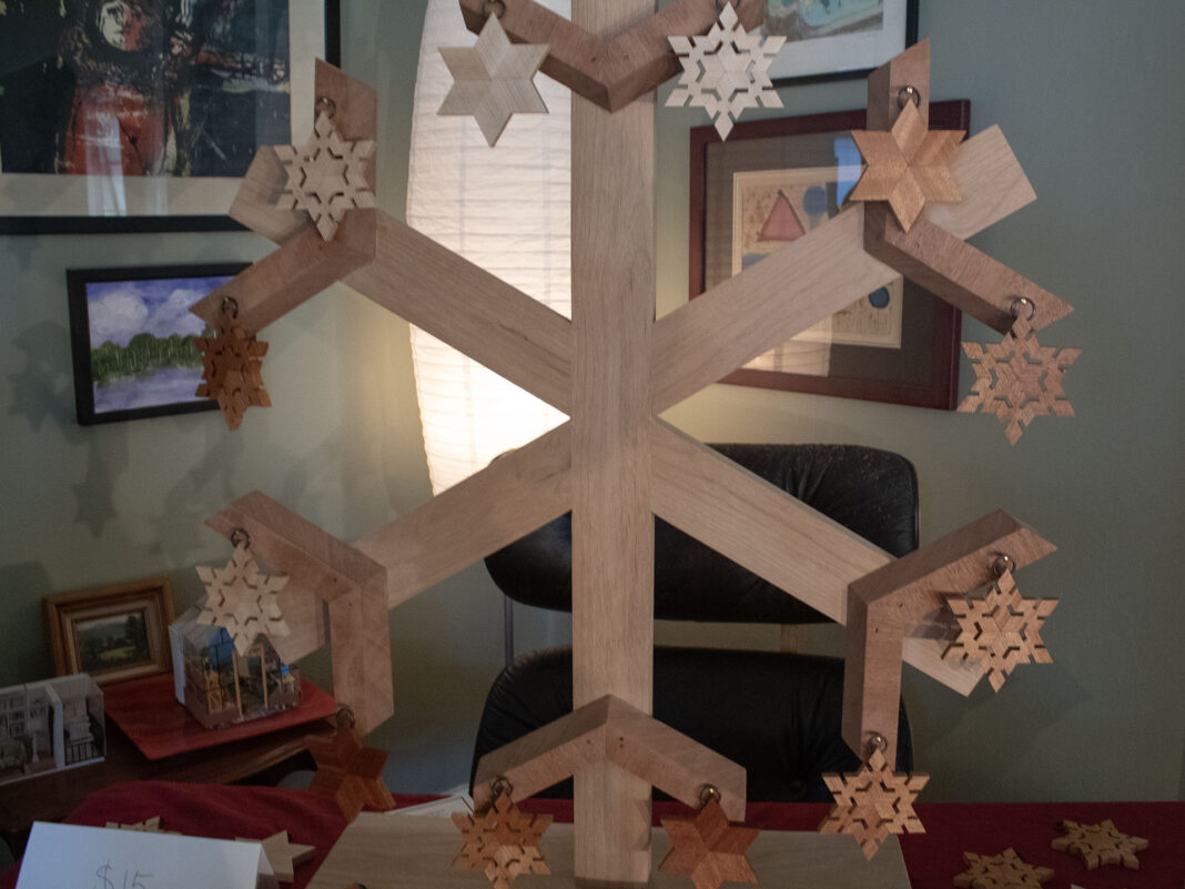 Wooden stars adorning a six-sided wooden snowflake stand