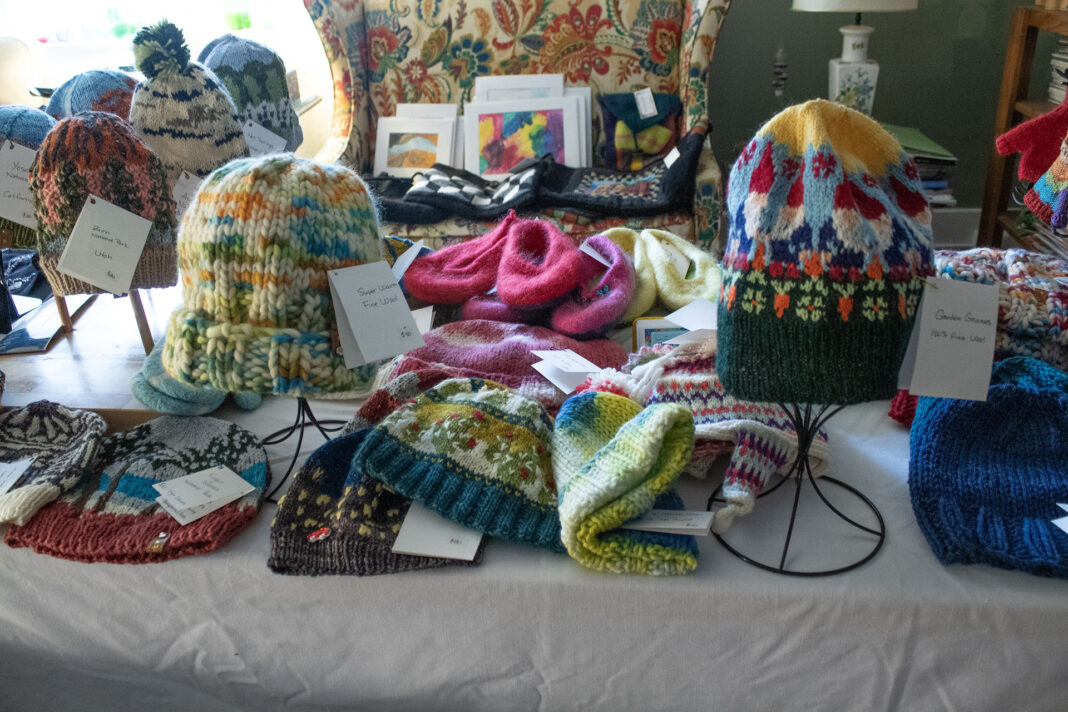 Multicolored knit clothing items being displayed on a table