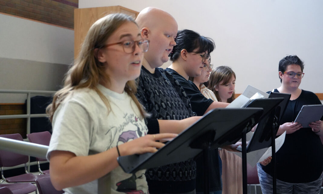 Student singing soprano as part of a choir