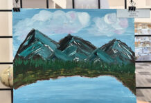 SLCC Library calls for artists to showcase work this fall Painting of mountains and a lake being displayed in a library