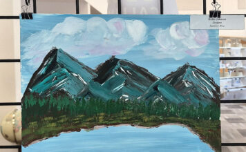 SLCC Library calls for artists to showcase work this fall Painting of mountains and a lake being displayed in a library