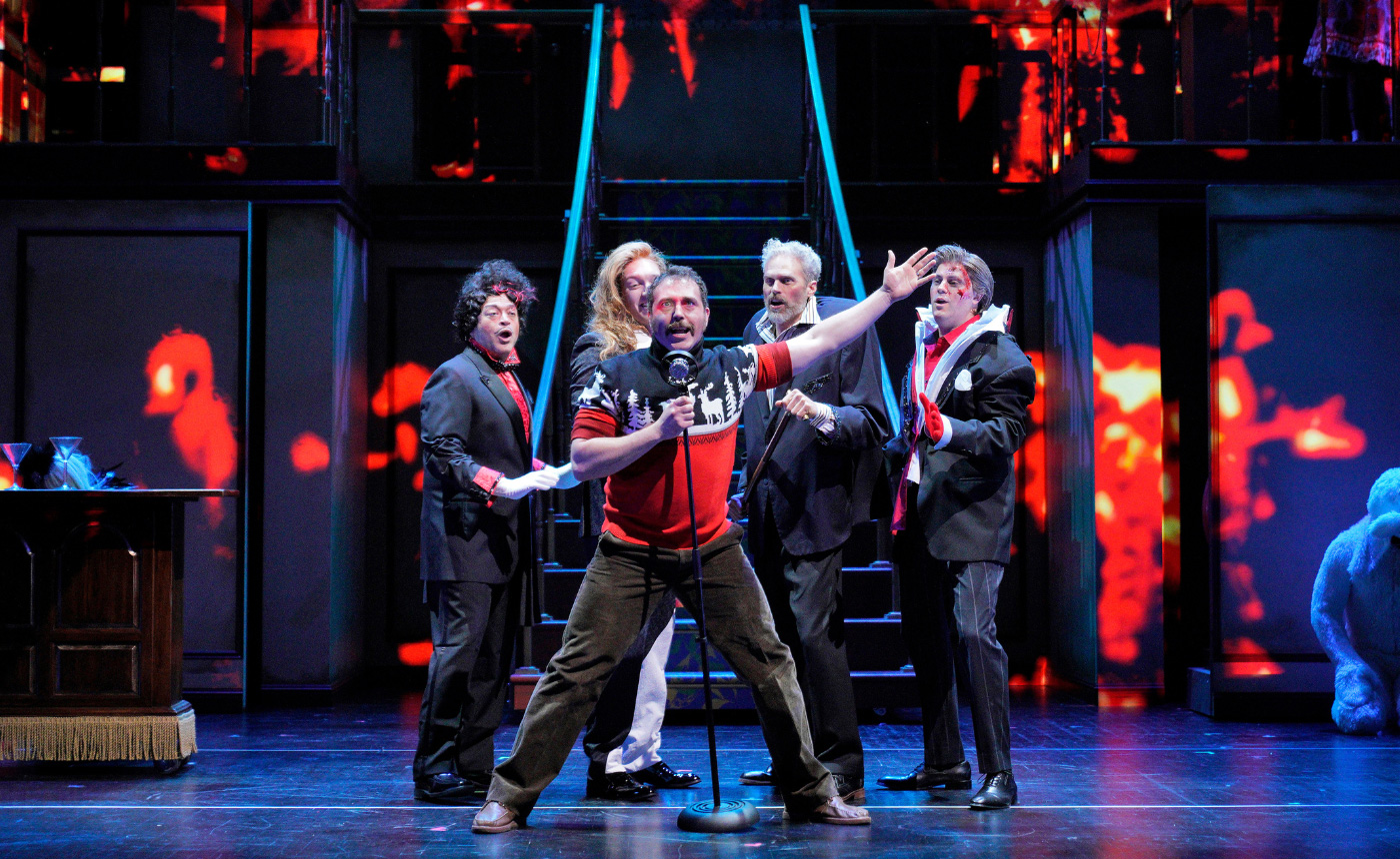 Craig Irvin performing as Jack Torrance on stage surrounded by other actors