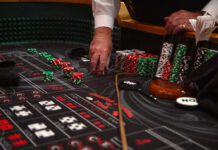 Photos: Casino Night energizes Redwood campus Craps dealer's hand holding a stack of red casino chips on a craps table