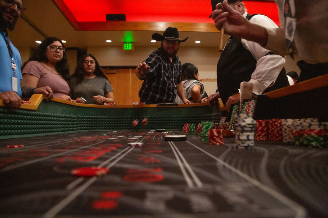 Man throws a pair of dice across the craps table
