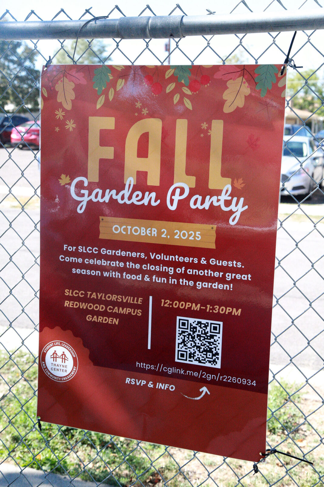 The fall Garden Party sign hanging on the garden fence