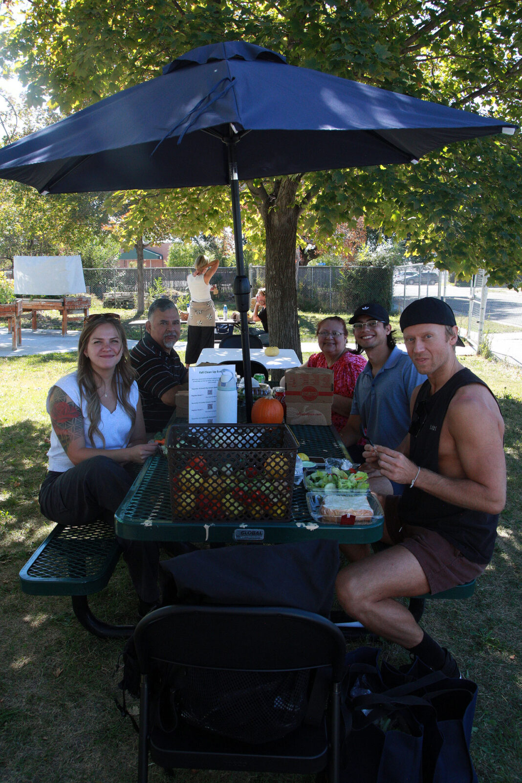 People sitting and socializing at a table with umbrella attached
