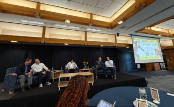 Student forum addresses concerns about tuition, program cuts Panelists sitting in chairs on a riser