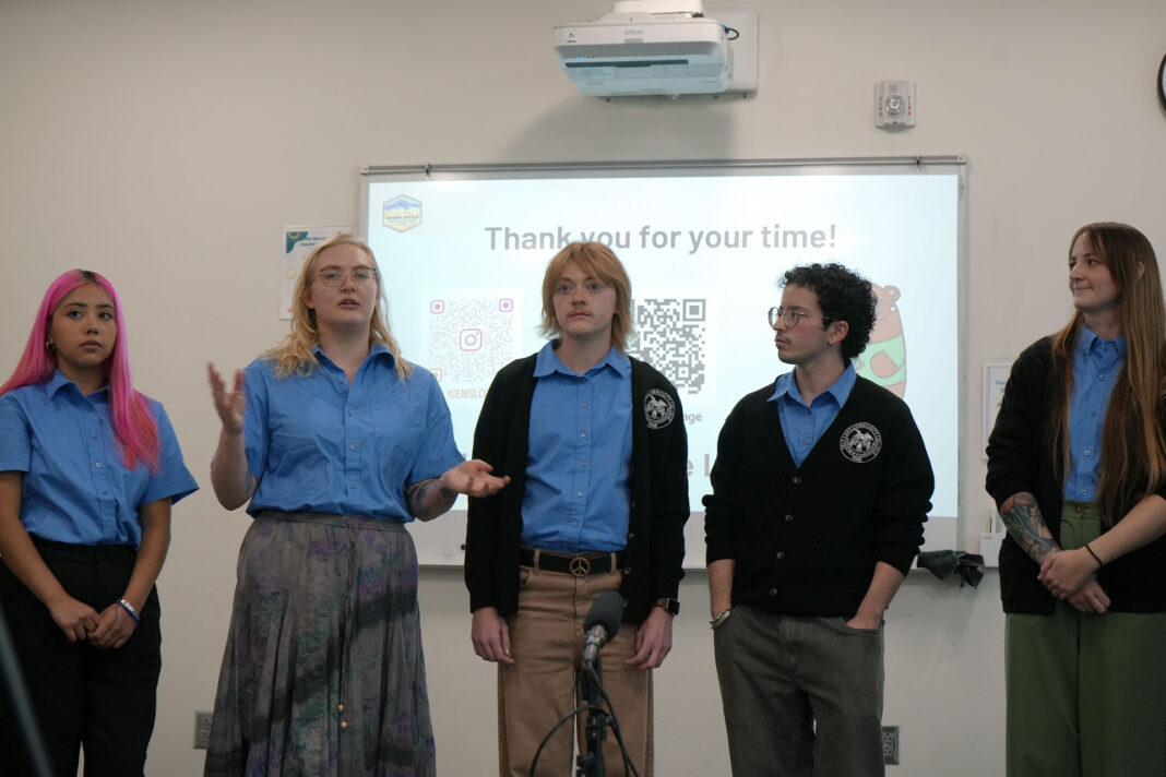 Science students wearing blue shirts and blazers answering questions