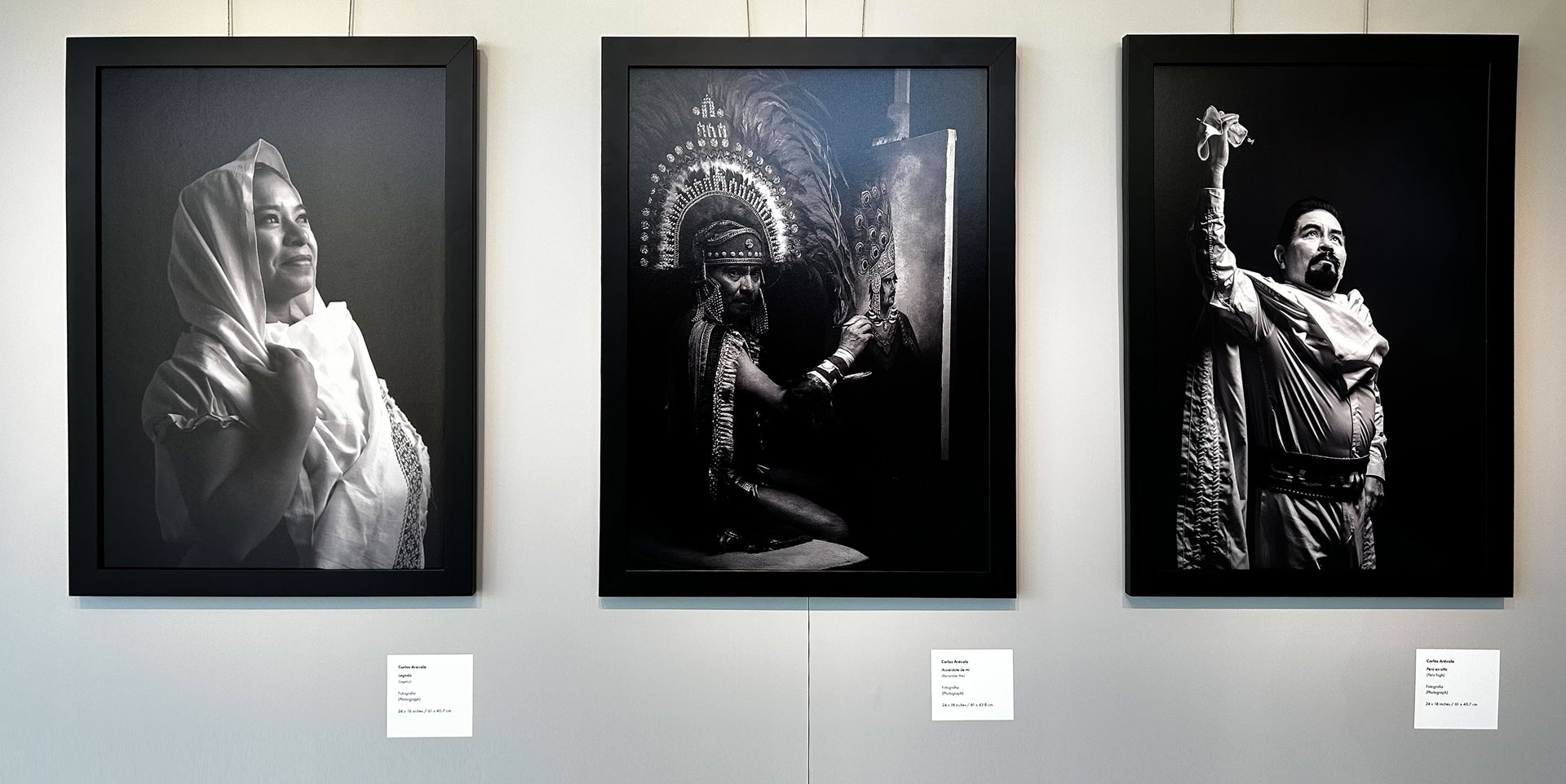 Three framed black-and-white photos hanging on a wall