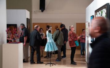 31st President’s Art Show celebrates creativity and community Several people looking at art exhibits in a multipurpose room