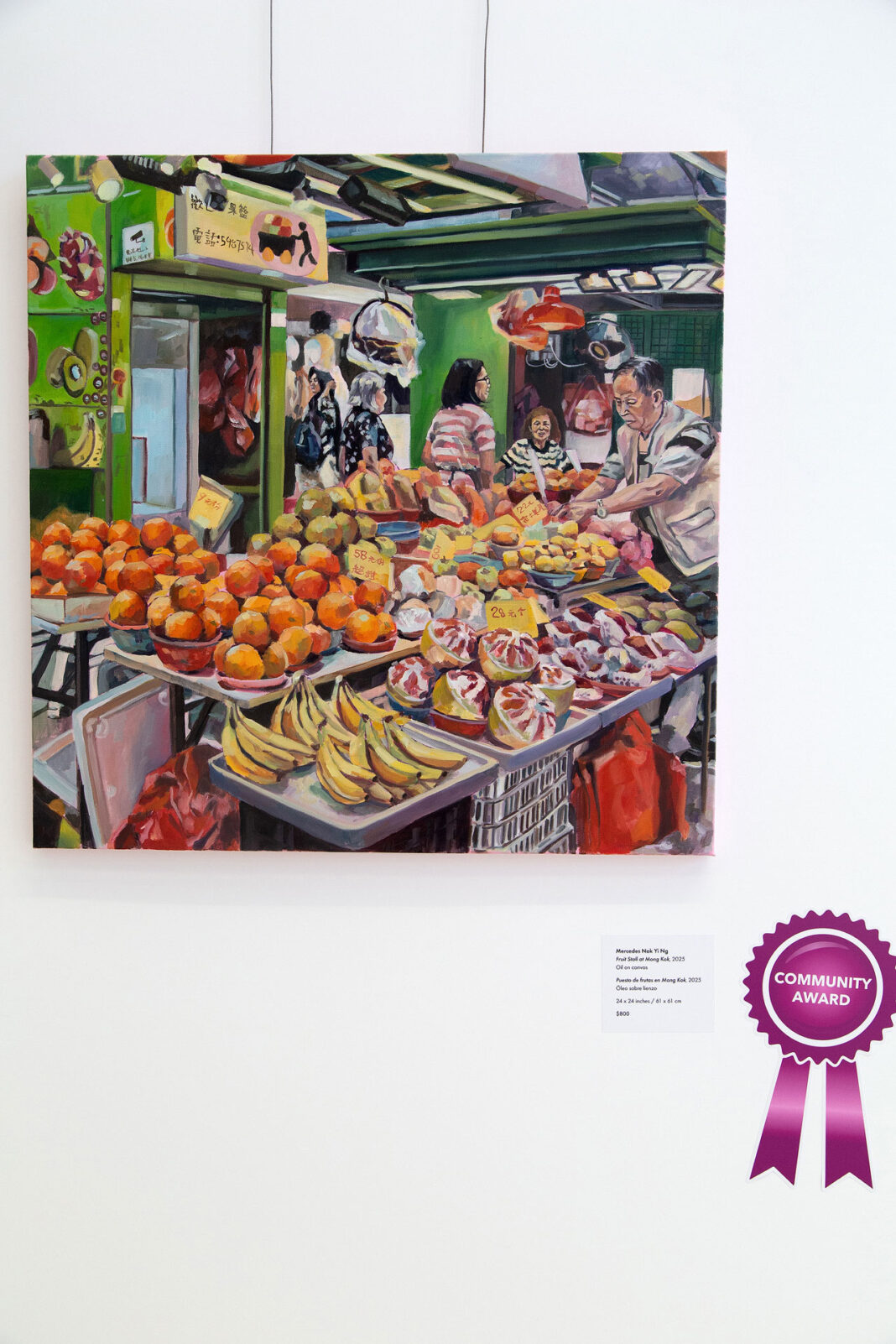 Painting hanging on a wall with a maroon colored ribbon signifying the community award winner