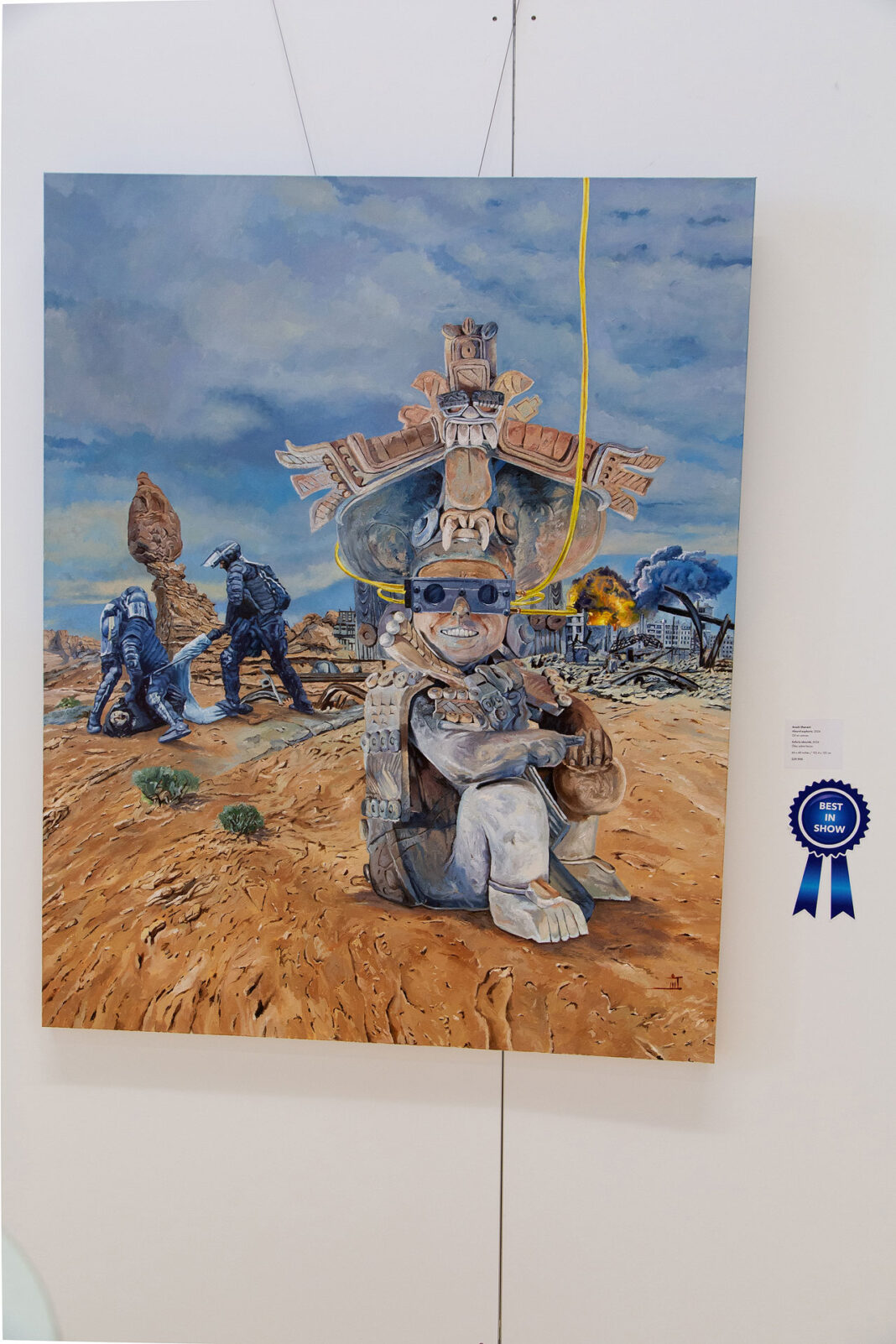 Painting hanging on a wall with a dark blue colored ribbon signifying the Best in Show winner
