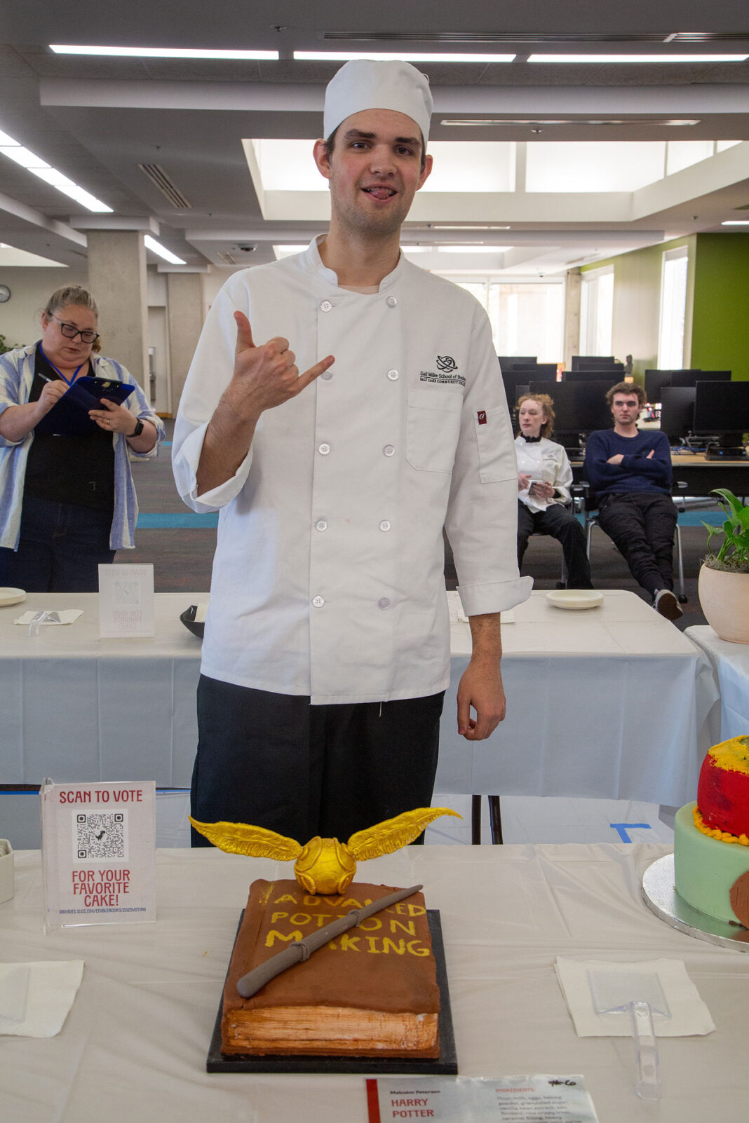 Malcolm posing with the "hang loose" hand sign behind his winning cake design