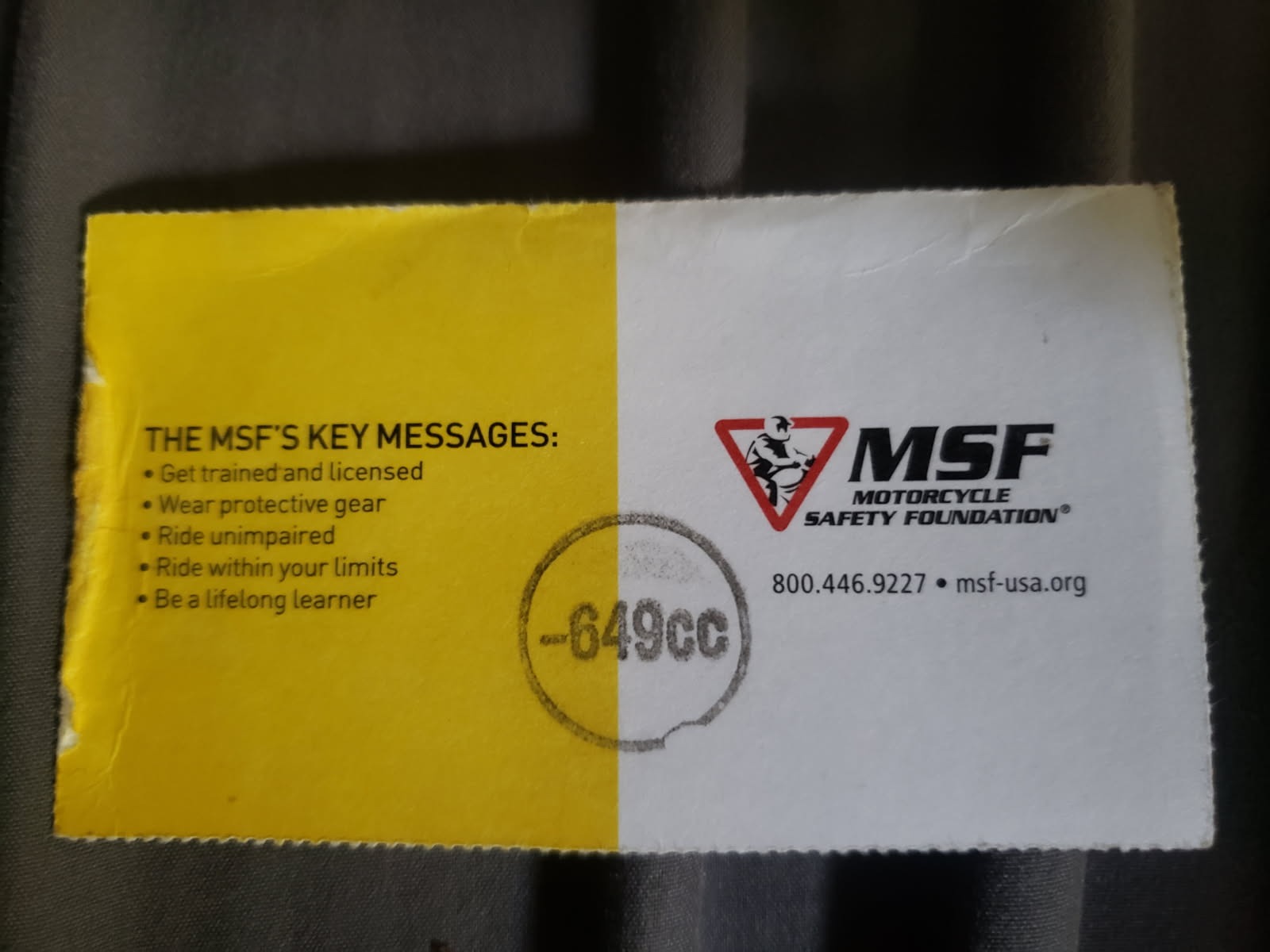 Yellow and white card with printed lettering and a stamp