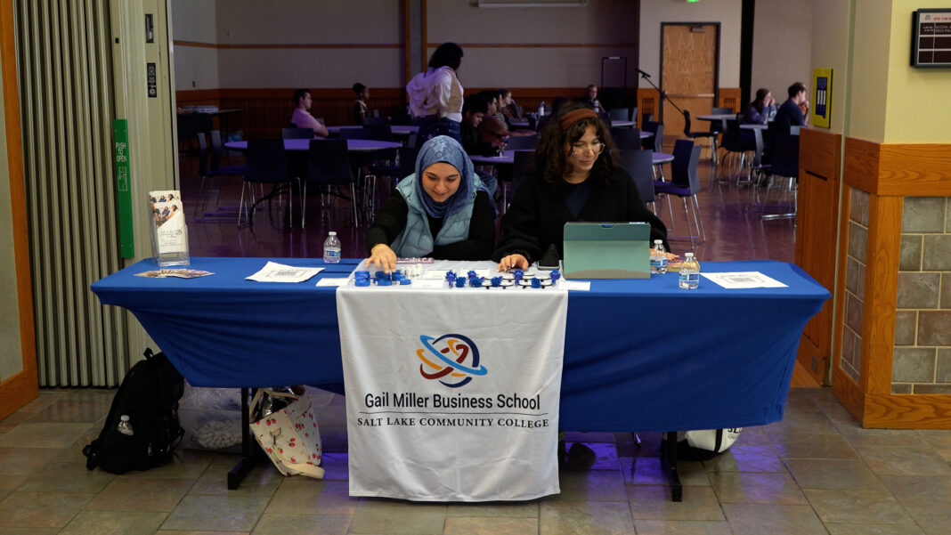 Two business students sitting at a table outside of a forum