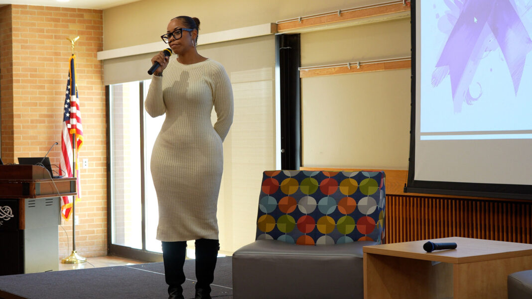 Chenoa using a microphone to welcome attendees