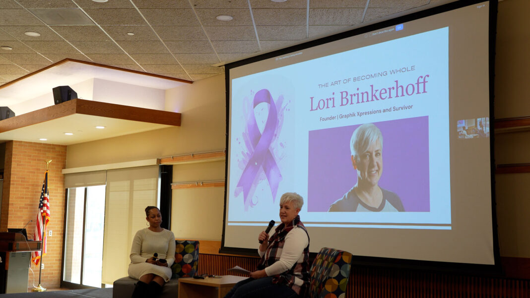 Lori talking to attendees from on stage as Chenoa listens