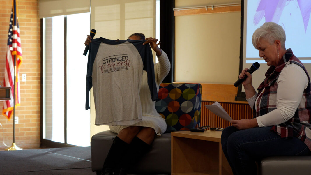 Chenoa holding up one of Lori's shirt designs as Lori talks