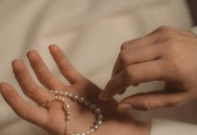 Poem: ‘The Serendipity Prayer’ a person's hands holding a pearl bracelet