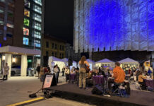 Musical, festival celebrate women’s suffrage and empowerment People walking around on a plaza at night