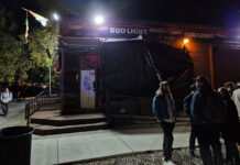 LGBTQ bar faces uncertainty after workers unionize People standing outside The Suntrapp bar at night