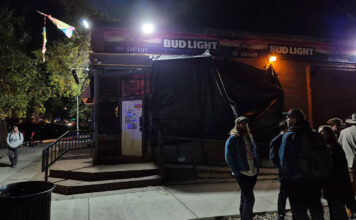 LGBTQ bar faces uncertainty after workers unionize People standing outside The Suntrapp bar at night