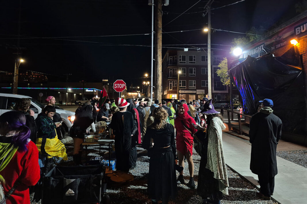 Dozens of people standing outside a bar at night
