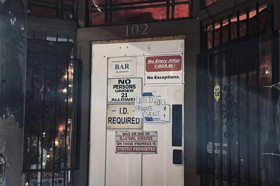 Signs with bar rules posted on white entry door
