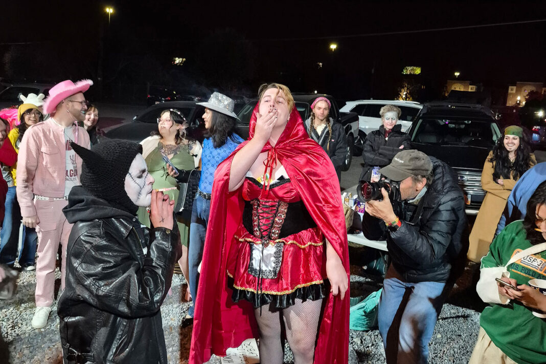 People wearing Halloween costumes and smoking cigarettes