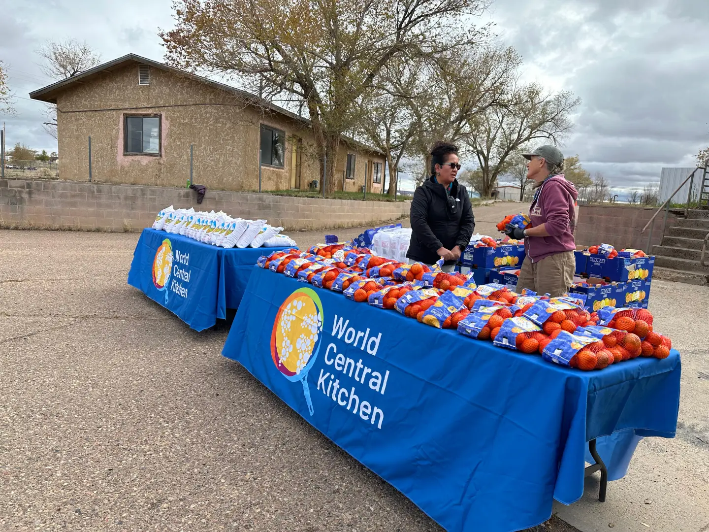 World Central Kitchen volunteers placing bags of oranges on a table