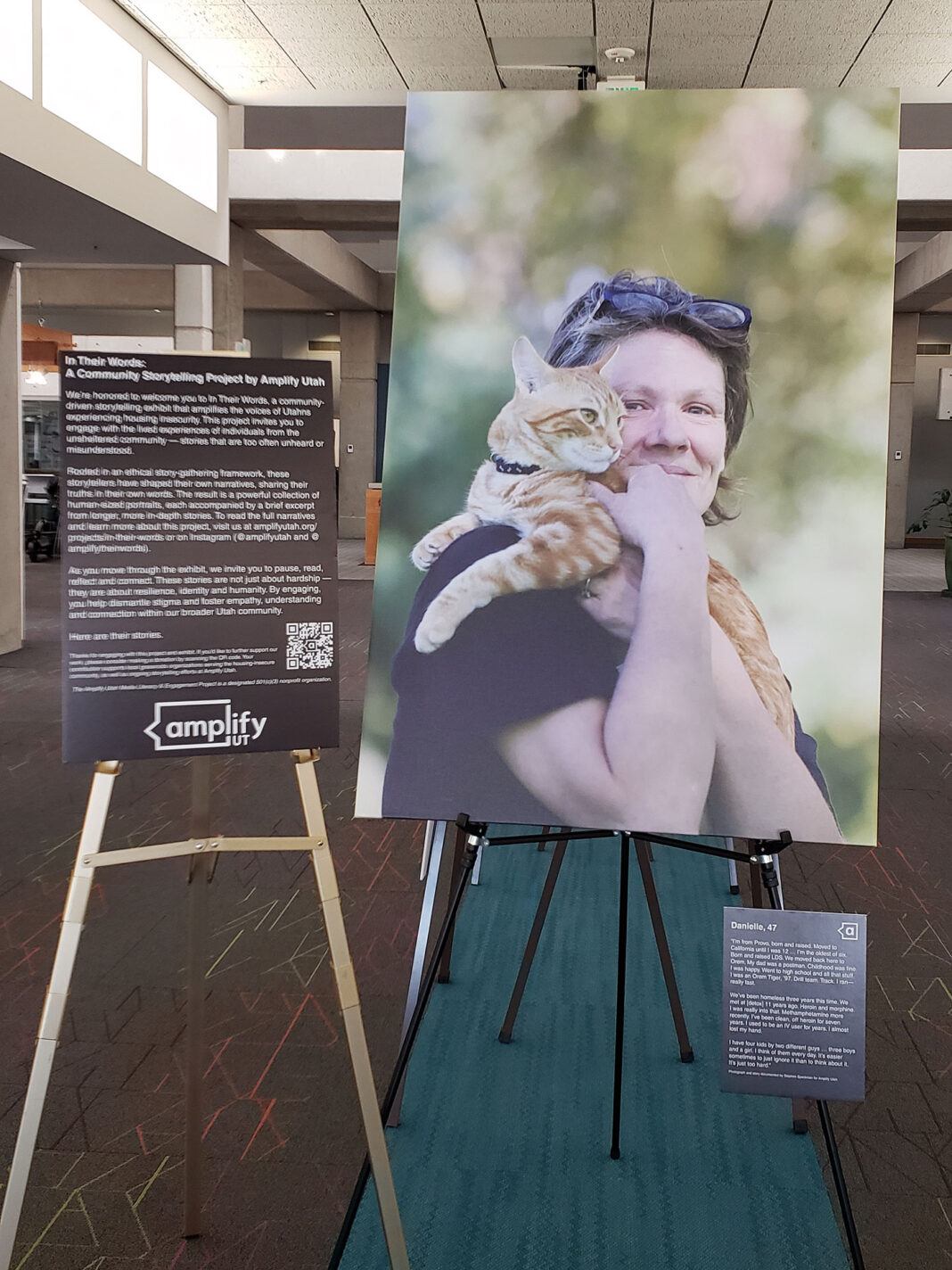 Large portrait on canvas sitting on easel next to exhibit placards