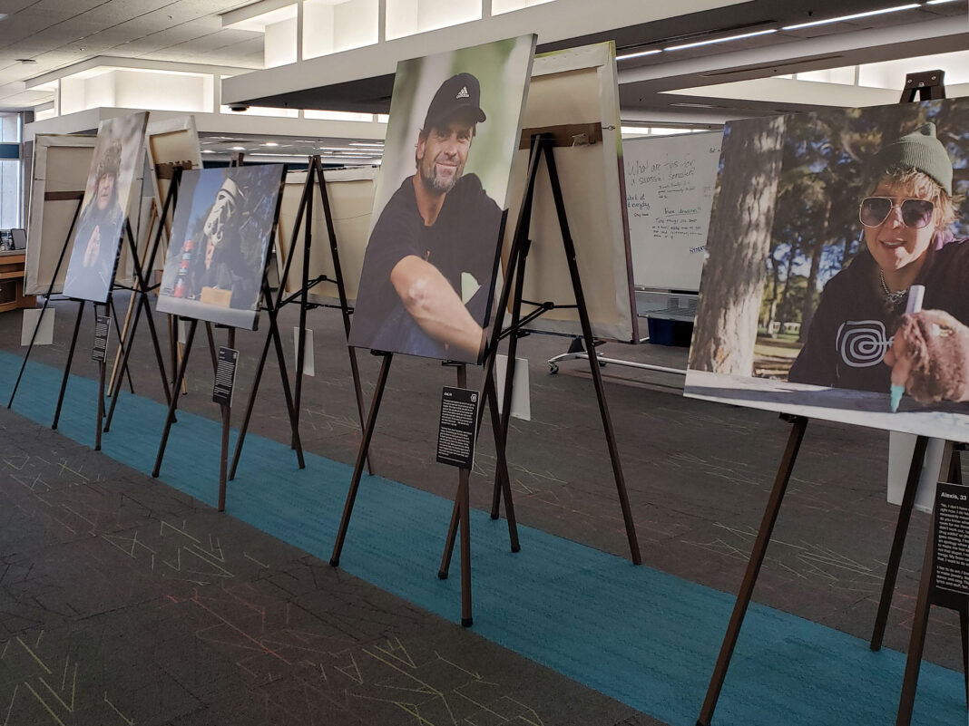 Portraits on canvas sitting on easels with placards describing the subjects