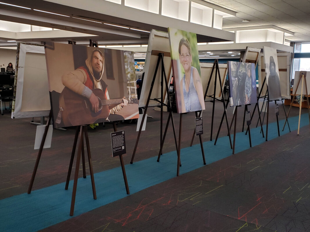 Portraits on canvas sitting on easels with placards describing the subjects