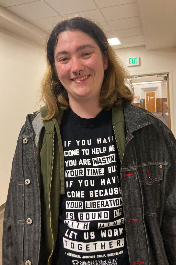 Kai Lyon smiling while standing in a hallway