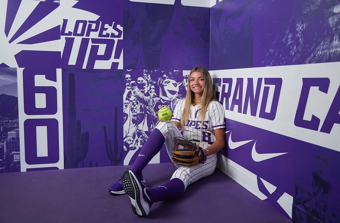 Ellie Pond wearing GCU softball uniform in school dugout