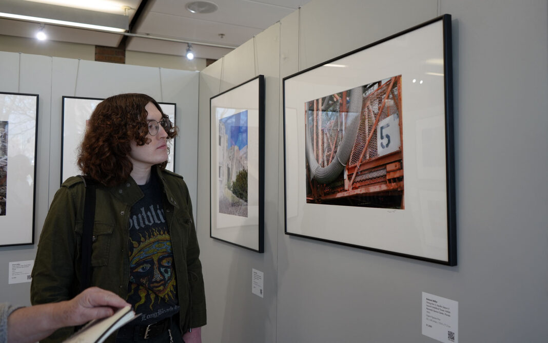 Chris looking at framed photography in a gallery