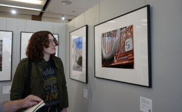Pop and fine art, roots and contemporary at play in current exhibits Chris looking at framed photography in a gallery
