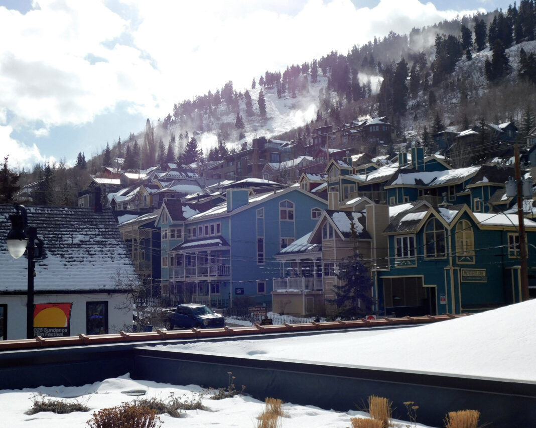 Buildings at base of a snowy mountain
