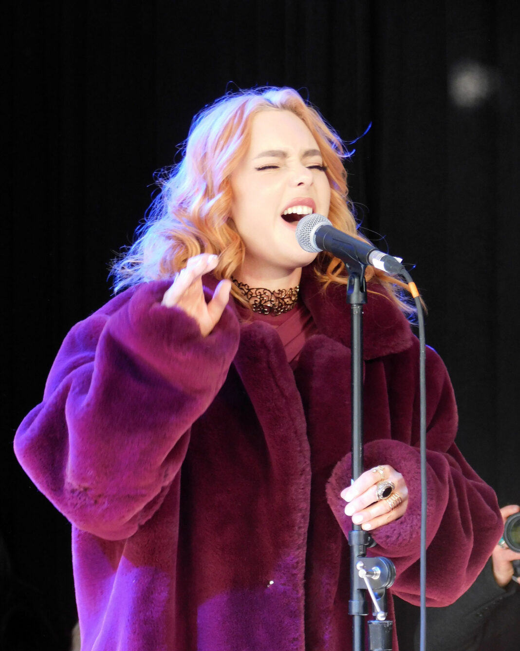 Nathalia singing in to a microphone