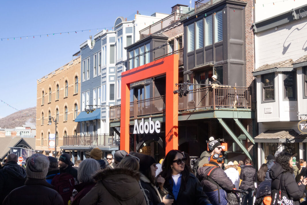 Landscape photo of the Adobe House Lounge in center frame with people and buildings surrounding it