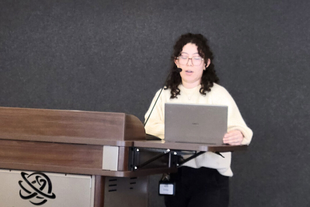 Erica Gudi&ntilde;o standing at a lectern while reading