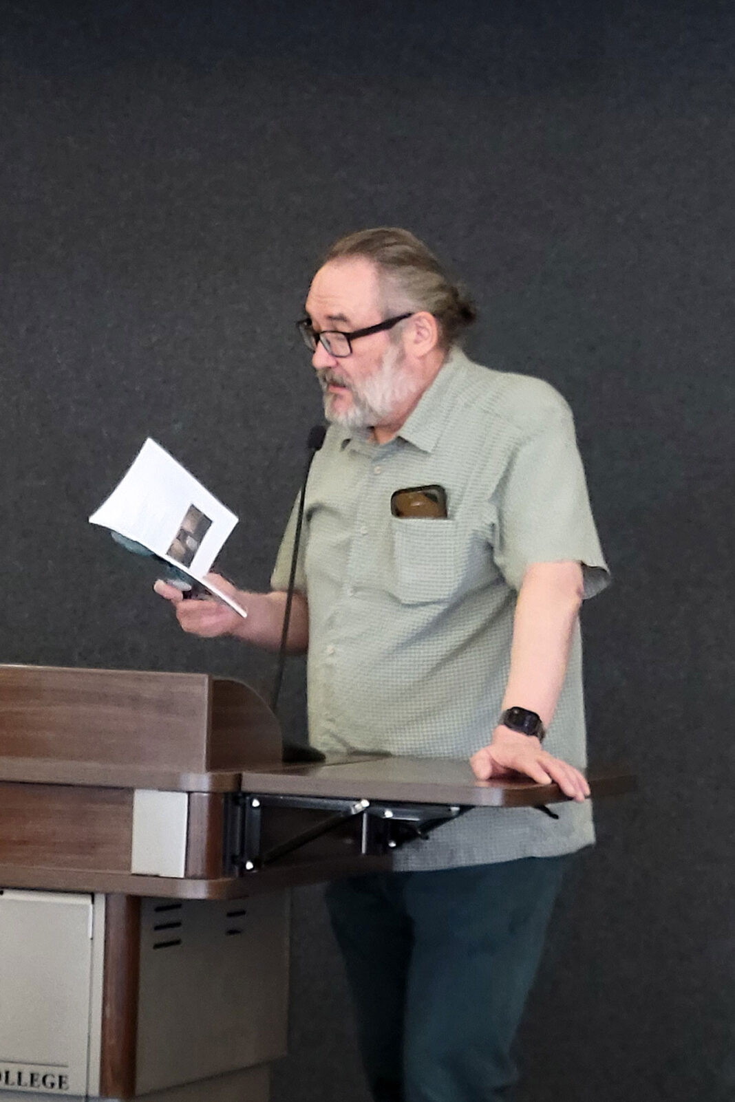 Clint Gardner standing at a lectern while reading