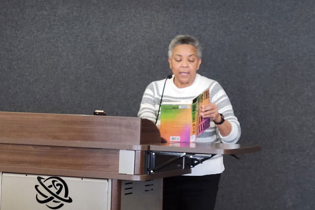 Jerri Harwell standing at a lectern while reading