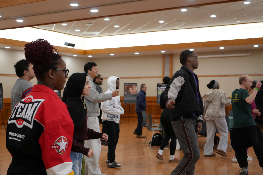 People of various backgrounds dancing in a large room